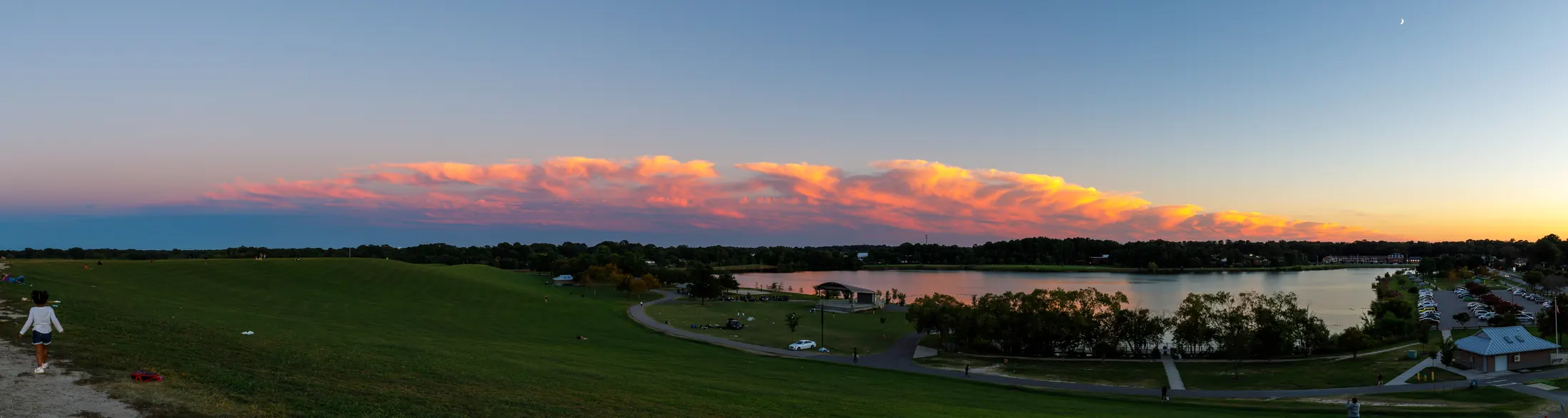 Panoramic sunset landscape over a park and water